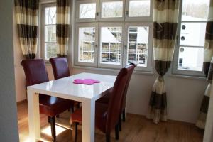 une salle à manger avec une table et des chaises blanches dans l'établissement Ledwig, Villa Emmi, à Heringsdorf