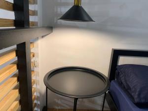 a black table next to a bed and a lamp at JORA LOFT- modern industrial apartment 1-A in Dagupan