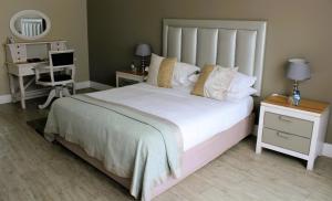 een slaapkamer met een groot wit bed en een bureau bij Atlantic Villa Boutique Guesthouse in Swakopmund