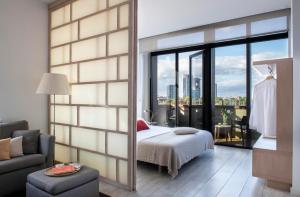 a bedroom with a bed and a large window at Eric Vökel Boutique Apartments - Amsterdam Suites in Amsterdam