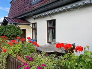 un porche de una casa con flores rojas en Moltke-Villa, en Teterow