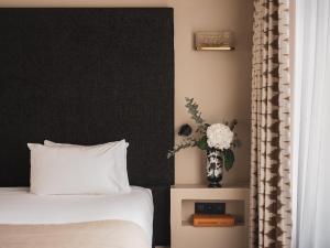 a bedroom with a bed and a vase with flowers at Le Rayz Vendome in Paris