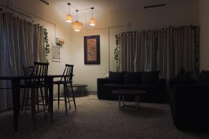 a living room with a couch and a table and chairs at Casilda By The Oaks Inn in Ernakulam