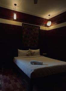 a bedroom with a bed with a blue towel on it at Casilda By The Oaks Inn in Ernakulam