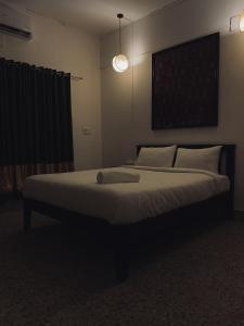 a bedroom with a large bed with a light on it at Casilda By The Oaks Inn in Ernakulam