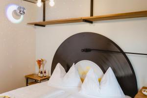 a bedroom with a bed with a black and white headboard at zum Sigismund - kiss & sleep in St. Wolfgang