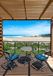 a patio with two chairs and a table on a deck at The Oyster Box Beach House by The Oyster Collection in Kenton on Sea