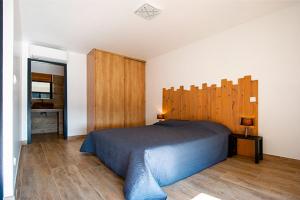 a bedroom with a large bed with a wooden headboard at Via Mare in Sainte-Lucie de Porto-Vecchio