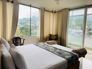 una camera da letto con un letto e una grande finestra di Quick Stop Inn a Kandy