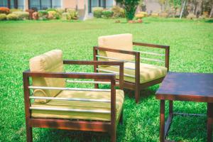 two chairs and a table in the grass at Moi Koggala by DBI in Habaraduwa