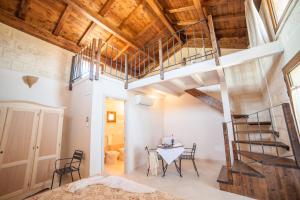 um loft com uma escada e uma mesa num quarto em Agriturismo La Palascìa Masseria Agreste em Otranto