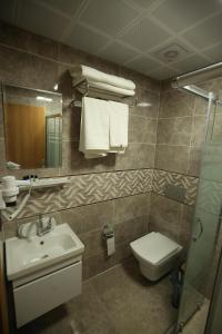 ein Badezimmer mit einem Waschbecken, einem WC und einem Spiegel in der Unterkunft BEYAZ İNCİ OTEL in Sivas