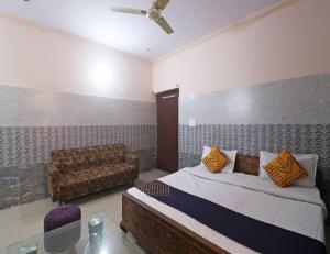 索尼帕特的住宿－Hotel Shri Ram Residency, Sonipat, Haryana，一间卧室配有一张床和一张沙发