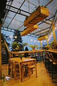 ein Restaurant mit einem Holztisch und Stühlen auf einer Terrasse in der Unterkunft Gạo House & Coffee in Sa Pa