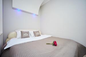 a bedroom with a bed with a pink rose on it at Apartment Grecheskie in Odesa