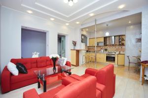 sala de estar con sofá rojo y mesa en Apartment Grecheskie, en Odessa