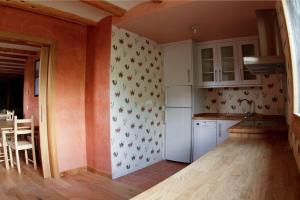 a kitchen with orange walls and a white refrigerator at CHECK-IN CASAS Borda Blaner in Villanova