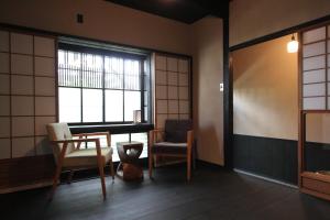 a room with two chairs and a table and a window at Brian Private Machiya in Higashiyama in Kyoto +24 photos