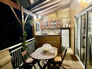 a small kitchen with a table and chairs on a balcony at Mahogany Lodge - Oasis cosy in Rivière-Pilote