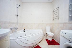 a bathroom with a tub and a toilet and a sink at Apartment Grecheskie in Odesa