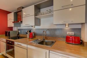 une cuisine avec des armoires blanches et un évier dans l'établissement BIOLAY 2 - Alpes Travel - Central Chamonix - Sleeps 4-6, à Chamonix-Mont-Blanc 35 autres photos