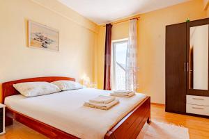 a bedroom with a bed with white sheets and a window at Siriščević Apartment in Korčula