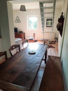 a dining room with a wooden table and chairs at La Muchette, maison au calme 3 chambres 2 salles d'eau in Juvigny