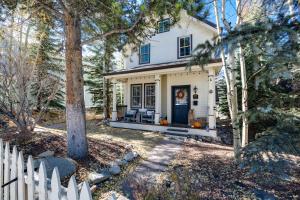 a white house with a white fence and trees at Ridge Street Chalet Home a Historic District Charm in Breckenridge