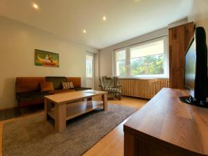 a living room with a couch and a coffee table at Apartamentai ŠERMUKŠNIS in Druskininkai