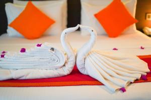 two swans towels are sitting on a bed at Moi Koggala by DBI in Habaraduwa