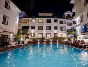 a pool in front of a hotel at night at Sunkissed Premium, Goa by WSI, Calangute Beach in Calangute