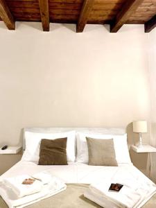 een wit bed met witte lakens en kussens bij Casa Mia Maria Margot LODI Self check in in Lodi
