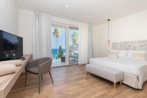 a white bedroom with a large bed and a television at Iancu Charme Apartments in Taormina