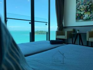 1 dormitorio con 2 camas y ventana grande en PD D'Wharf Premium Suite - Full Seaview (Up to 6 Pax) en Port Dickson
