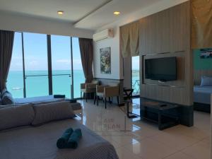 sala de estar con sofá y TV de pantalla plana en PD D'Wharf Premium Suite - Full Seaview (Up to 6 Pax) en Port Dickson