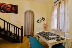 GR Stays WHITE HOUSE 4bhk Private Pool Villa in Calangute في كالانغيُت: غرفة معيشة بها درج ونافذة