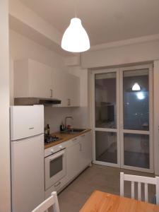 Il comprend une cuisine équipée d'un réfrigérateur blanc et d'une table. dans l'établissement B&C rentals and events, à Lecce