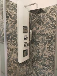 La salle de bains est pourvue d'une douche et de papier peint noir et blanc. dans l'établissement B&C rentals and events, à Lecce