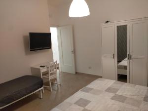 - une chambre avec un lit, un bureau et une télévision dans l'établissement B&C rentals and events, à Lecce