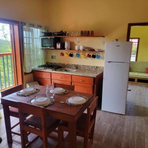 a kitchen with a table and a white refrigerator at Tropical Paradise View in Anse La Raye