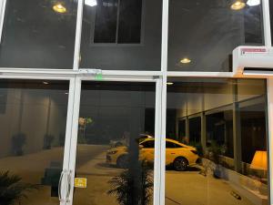 un reflet d'une voiture dans la fenêtre d'un bâtiment dans l'établissement เอสซีใสวัฒนา, à Ban Don Rak