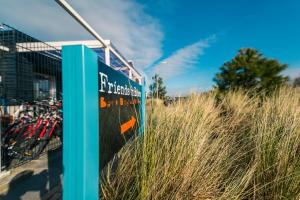 a sign in front of a building with tall grass at EuroParcs Poort van Zeeland in Hellevoetsluis