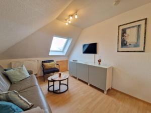 a living room with a couch and a table at Ferienhaus Nici Wohneinheit Leuchtturm in Norden