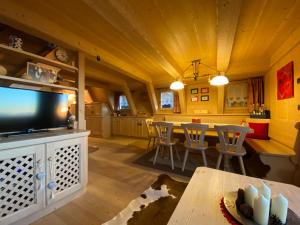Il comprend une cuisine et un salon avec une table et une télévision. dans l'établissement Cozy Mountain Chalet, à Cavalese 13 autres photos