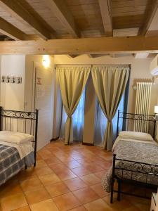 1 dormitorio con 2 camas y ventana grande en La Casina, en Dello