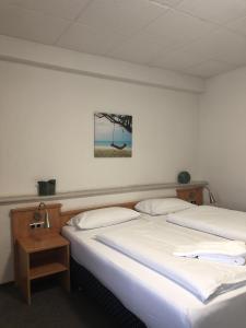 dos camas sentadas una al lado de la otra en una habitación en Gasthaus zum Ritter, en Karlsdorf-Neuthard