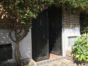 una entrada a un edificio con una puerta negra en Las Gitanillas, villa with heated pool, La Cala de Mijas, en Mijas Costa