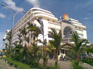 a large white building with palm trees in front of it at Pacific Palace Hotel in Nagoya