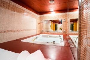 a bathroom with a tub and a mirror at Marcantonio Hotel in Giugliano in Campania