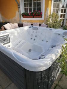 uma banheira de hidromassagem sentada fora de uma casa em Vár-Lak Resort em Balatonederics